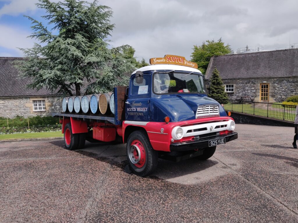 A blue and red vintage transport truck with distillery branding