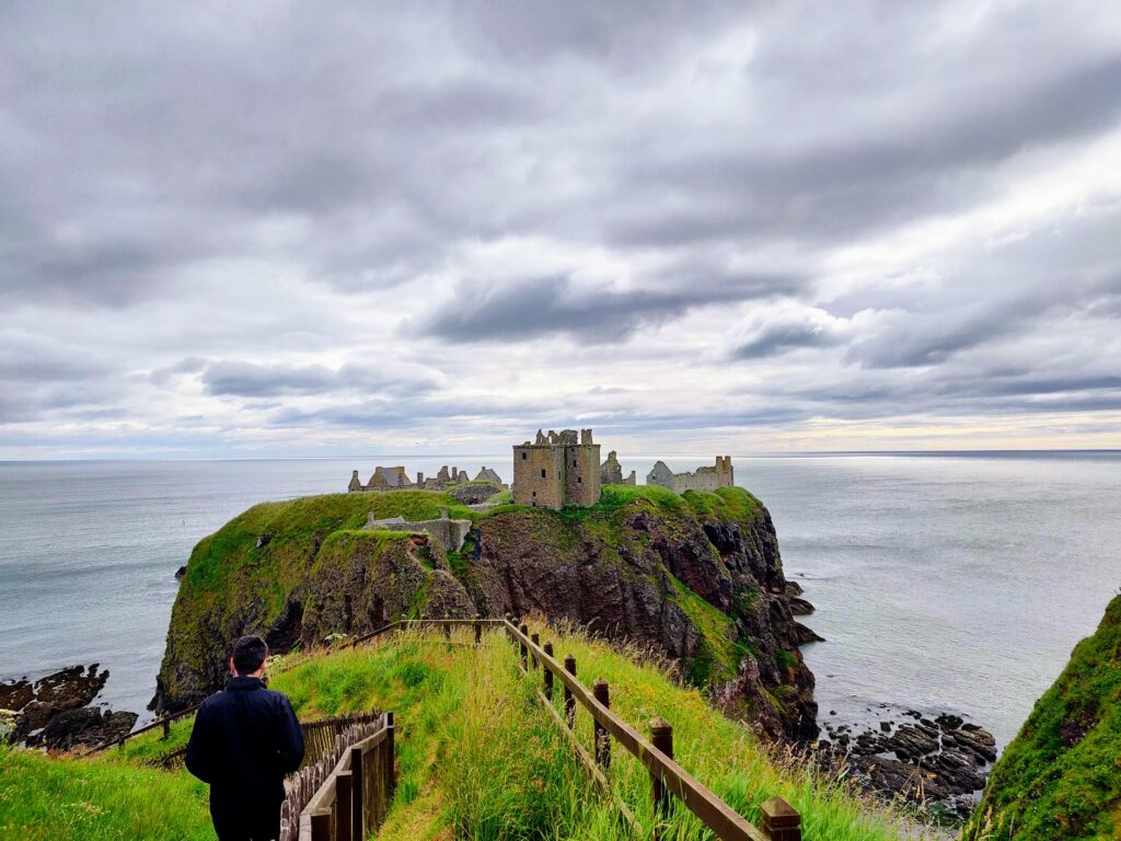 Dunnottar Castle located on its own little rock island, with views across the ocean. View looking towards the castle during our scottish highlands road trip during our 10 days in Scotland